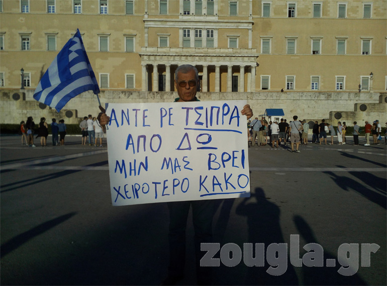 Διαδηλωτής κρατάει πανό το οποίο γράφει: «Άντε ρε Τσίπρα από δω μην μας βρει χειρότερο κακό» 