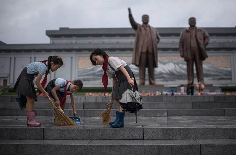 Νεαρές μαθήτριες σε εθελοντική εργασία: Καθαρίζουν τον χώρο μπροστά στο μνημείο των δύο προηγούμενων ηγετών της Β. Κορέας