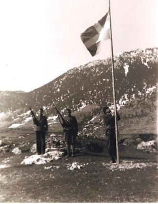  Έπαρση σημαίας στην Αγόριανη (Μάρτιος 1943). Όπλα παρουσιάζουν –με τον αντάρτικό τρόπο που είχε καθιερώσει ο Άρης- ο Χ, Κουρέλης από τη Λαμία, και ο Γ. Μέτος από τη Στρώμη. Στη σημαία ο Νικηφόρος.