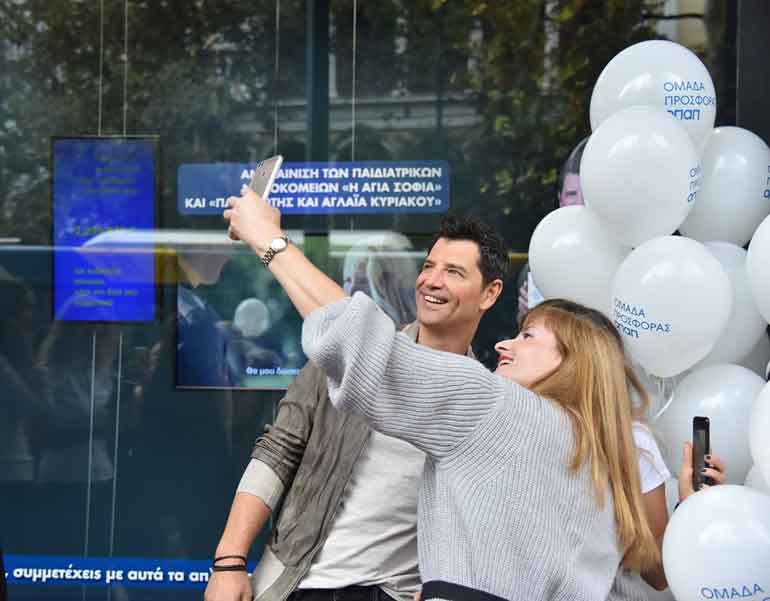 O Σάκης Ρουβάς φωτογραφίζεται με μέλη της ομάδας προσφοράς ΟΠΑΠ