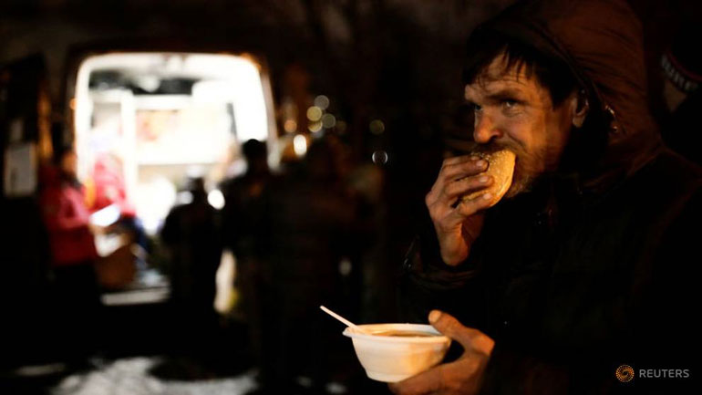 Άστεγος απολαμβάνει το γεύμα του