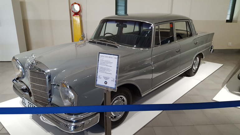 Η Mercedes Benz 230S κατασκευάστηκε μεταξύ 1959 και 1971 και παρουσιάστηκε στην έκθεση της Φρανκφούρτης το 1959. Η συγκεκριμένη είναι μοντέλο του 1965 εφοδιάζεται με εξακύλινδρο (σε σειρά) κινητήρα χωρητικότητας 2.306 κ.εκ. με 120 ίππους, έχει αυτόματο κιβώτιο 4 σχέσεων και η τελική ταχύτητα αγγίζει τα 174 χλμ./ώρα. 