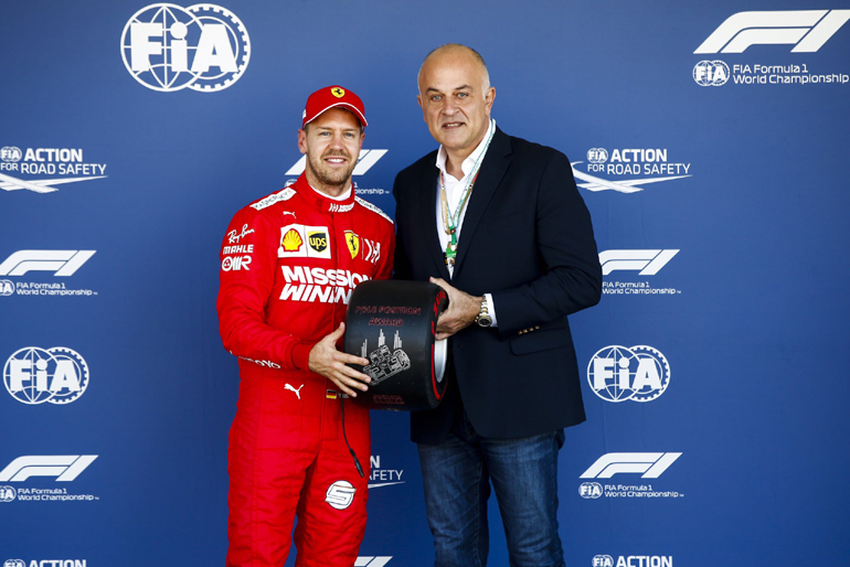 Ο Δημήτρης Παπαδάκος παραδίδει το ελαστικό στον Poleman του GP της Ιαπωνίας, Sebastian Vettel