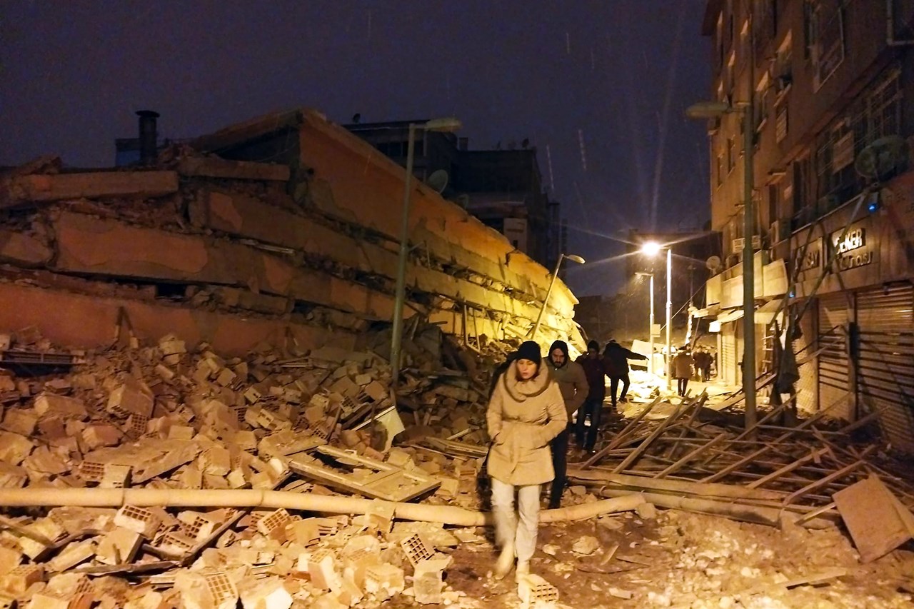 Κόσμος περπατά δίπλα σε κτήρια που καταστράφηκαν από τον σεισμό στη Μαλάτεια Τουρκίας