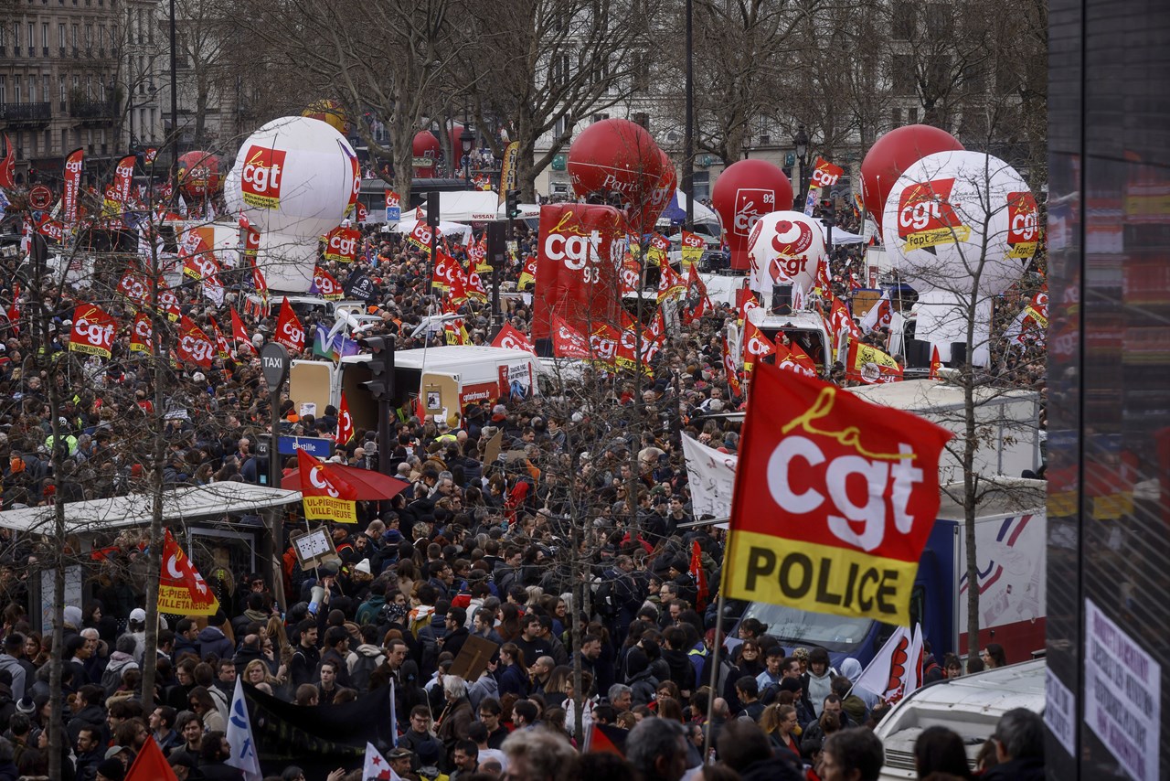 Διαδηλωτές συγκεντρώνονται στην Πλατεία της Βαστίλλης κατά τη διάρκεια συγκέντρωσης στο Παρίσι. Η αφίσα αριστερά, απεικονίζει τον Γάλλο Πρόεδρο Εμανουέλ Μακρόν και γράφει «η σύνταξή μου πριν από τη δική σας»