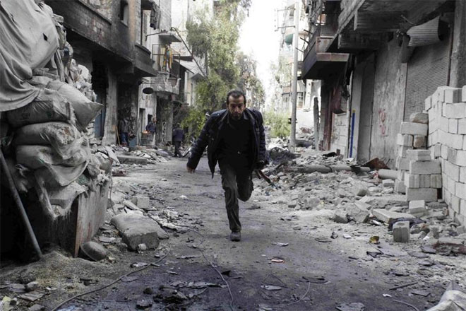 Χαλέπι, 29 Νοεμβρίου. Μαχητής του Συριακού Απελευθερωτικού Στρατού τρέχει στους δρόμους της πόλης, προκειμένου να αποφύγει τους ελεύθερους σκοπευτές