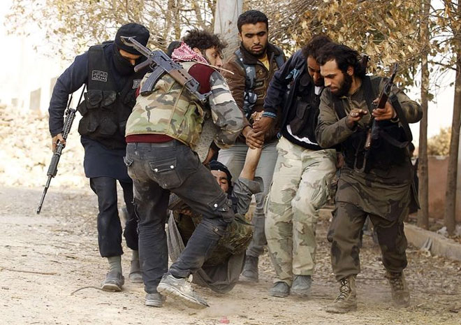 Χαλέπι, 8 Νοεμβρίου. Μέλη του Συριακού Απελευθερωτικού Στρατού μεταφέρουν έναν τραυματία στην περιοχή του αεροδρομίου της πόλης